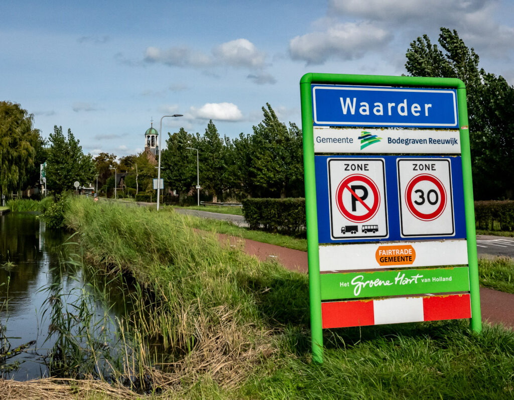 Het dorpsportaal met op de achtergrond de markante torenspits van de Hervormde Kerk in Waarder
